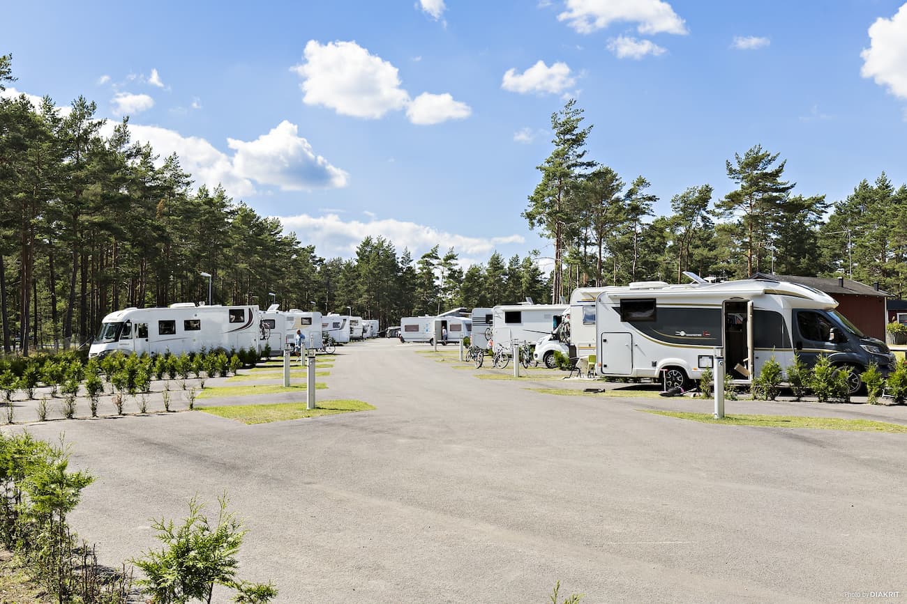 Bobilplass i Åhus på asfalt med egen gressplass ved siden.