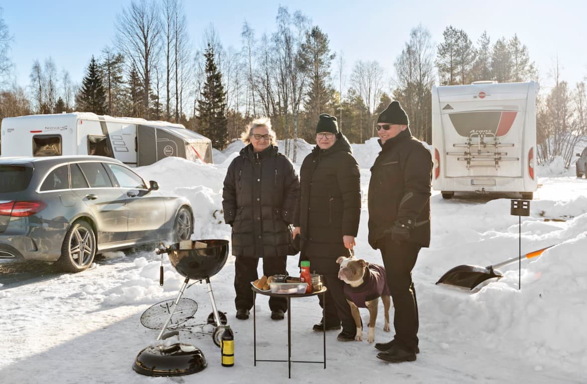 Hund nyter en vinterlig campingopplevelse med familien sin.