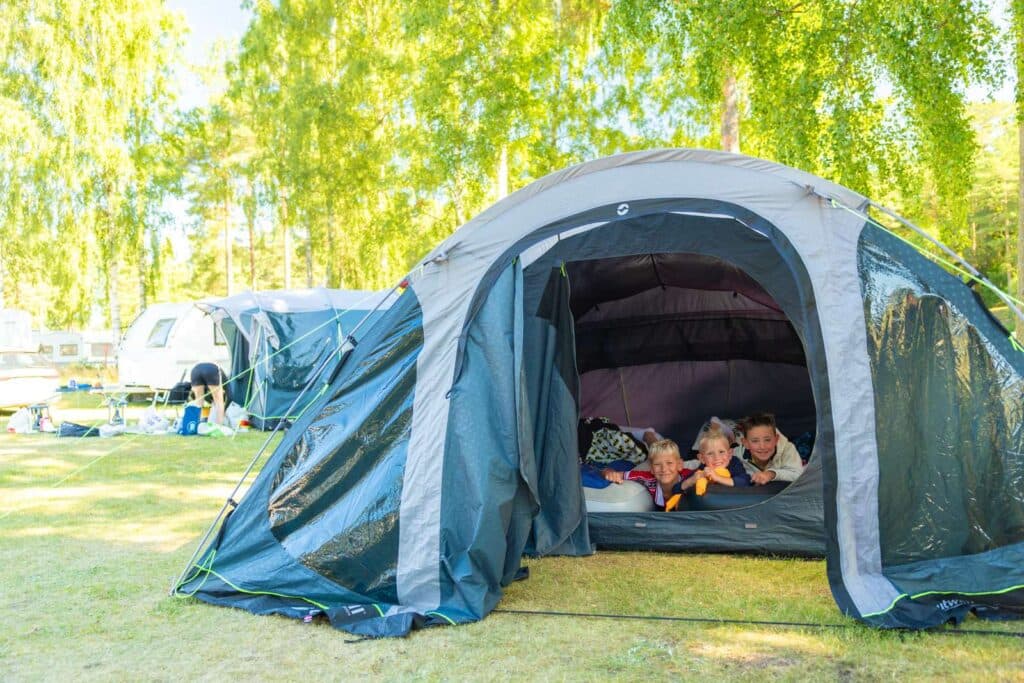 Barn som kikar ut från tält på Skara Sommarland camping