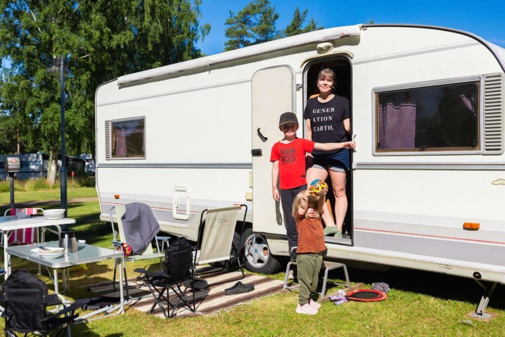 Familj som tittar ut från husvagn på Skara Sommarland camping