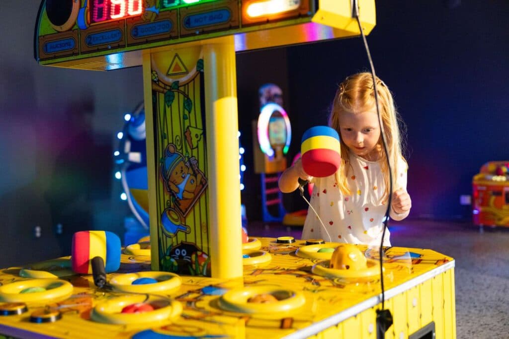 Barn som spelar ett spel inne i spelhallen på Skara Sommarland camping
