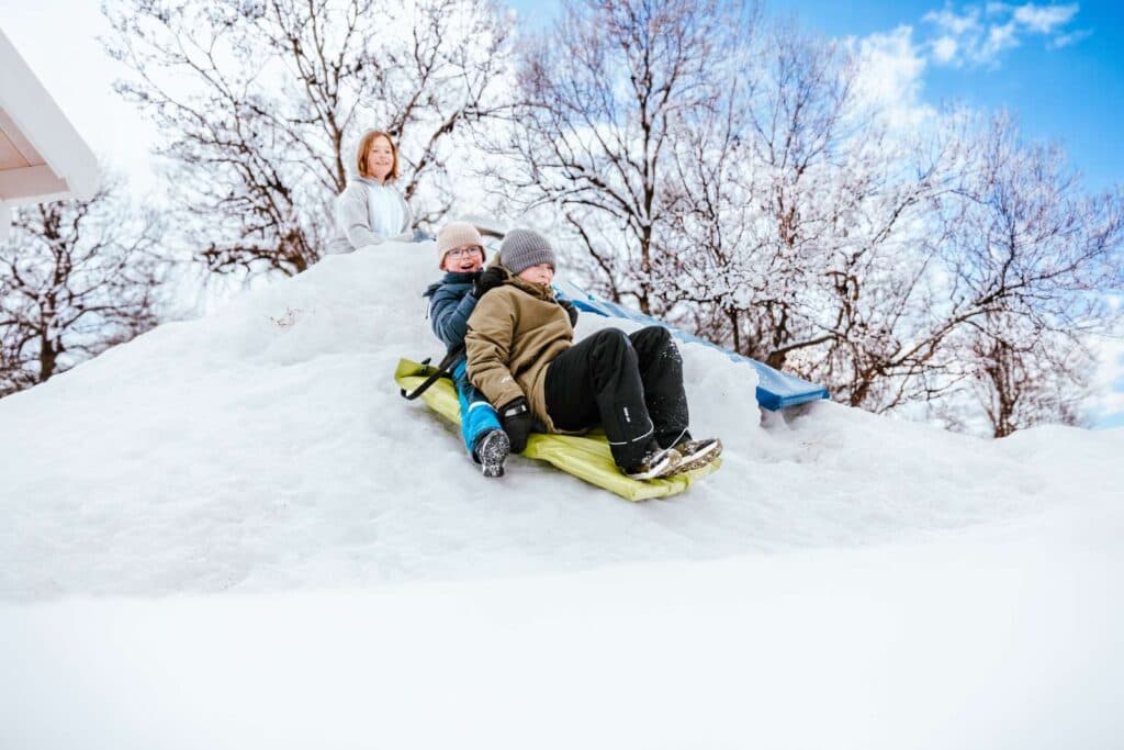 Barn som leker i snøen på First Camp Beitostølen campingplass – Valdres